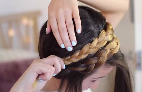 An image of one of the steps of how to do a milkmaid braid. 