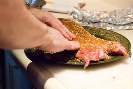 Pork back ribs, being rubbed with a dry rub