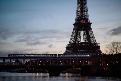 A Paris metro line train crosses the Seine in front of the Eiffel Tower, February 23, 2024