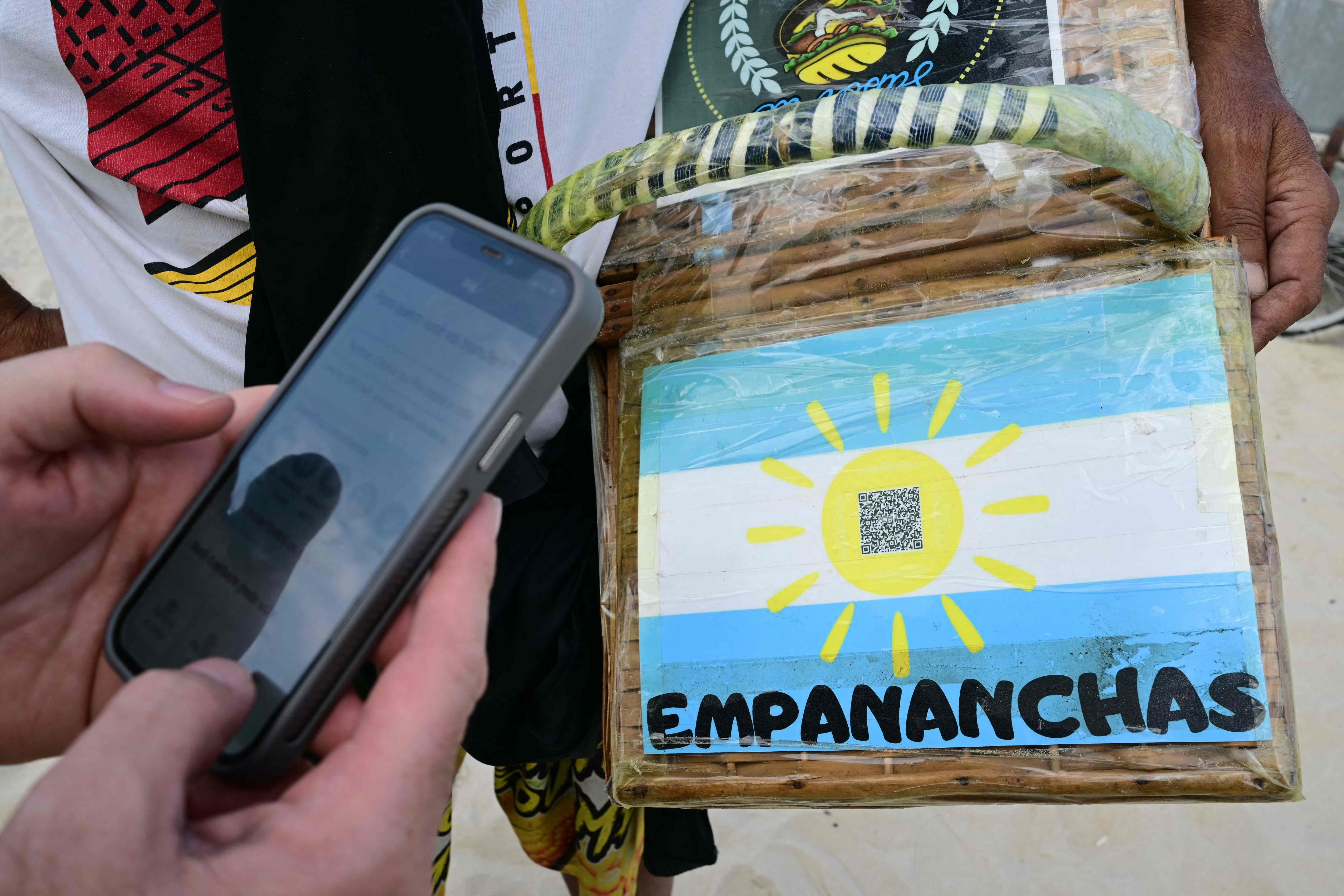 A man pays for a purchase on Copacabana Beach using Brazil's Pix instant payment system, in Rio de Janeiro, July 9, 2026.