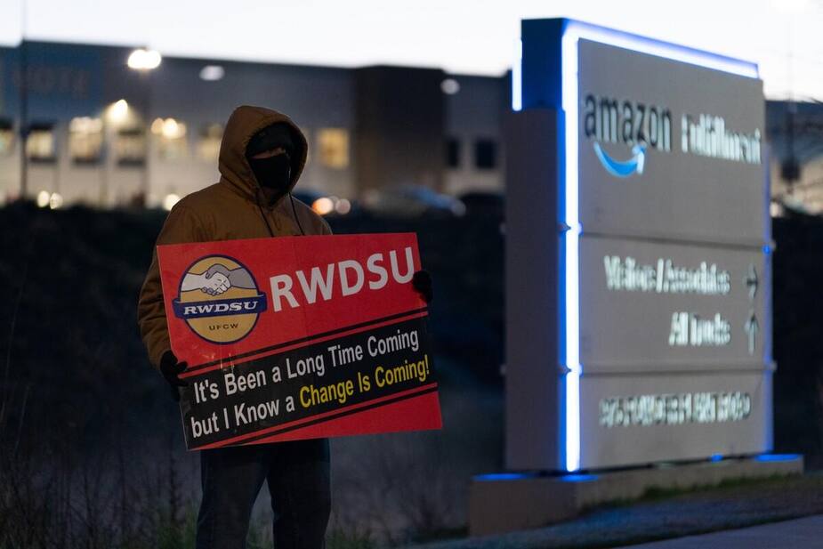 Un employé tenant une pancarte encourageant à voter «pour» la syndicalisation à l'extérieur de l'entrepôt d'Amazon à Bessemer en Alabama, le 29 mars 2021.Le vote du «non» a finalement sorti vainqueur.