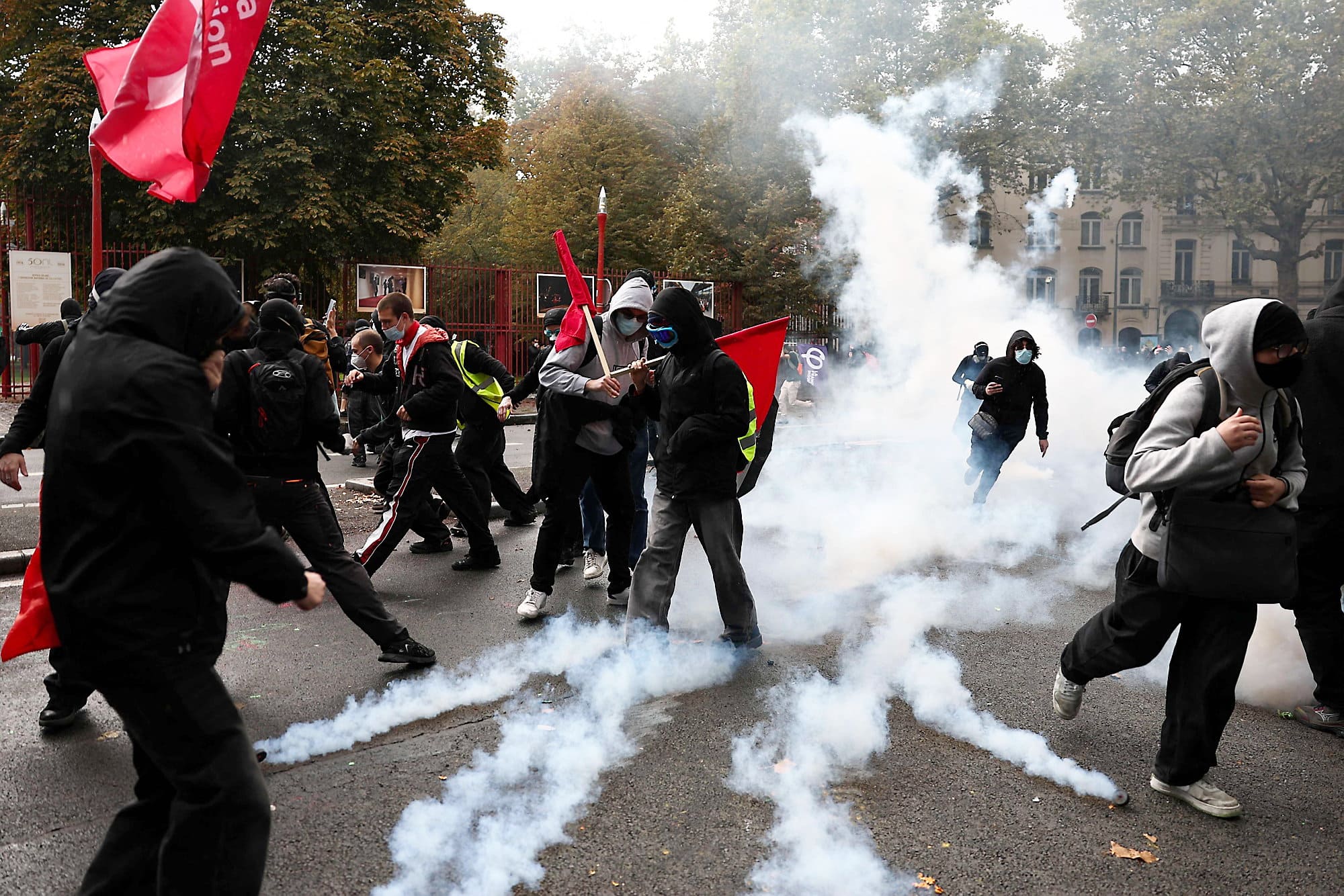 Des manifestants marchant à travers le gaz lacrymogène le 17 octobre 2026, à Lille.