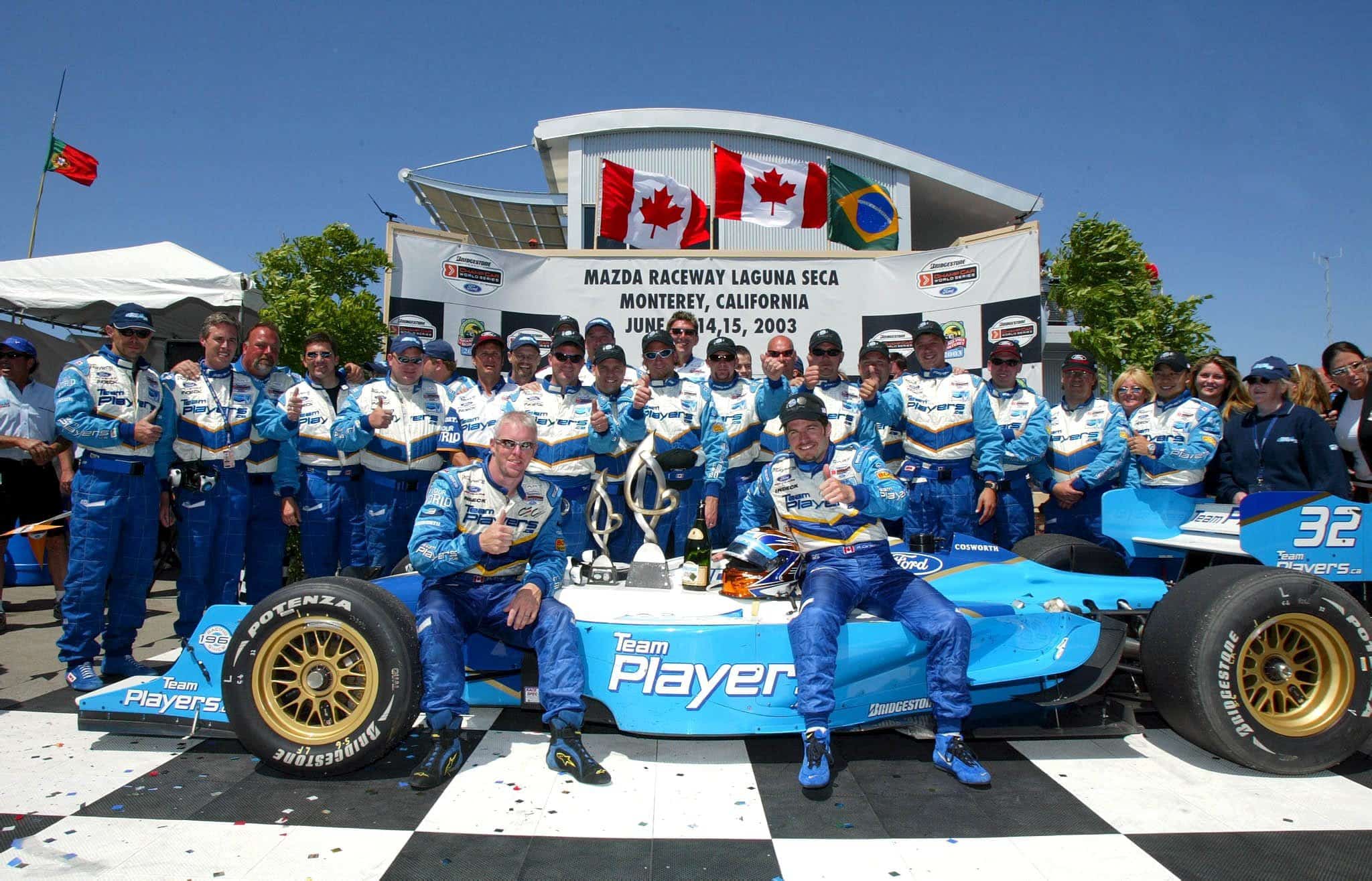 Patrick Carpentier célèbre sa victoire au Grand Prix de Monterey, en Californie, en Champ Car. Il est en compagnie de son coéquipier Paul Tracy et des membres de l'écurie Player's en 2003.