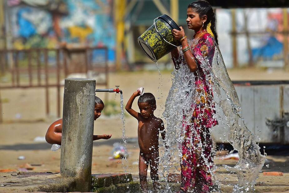 Une femme et son enfant se rafraîchissent à Prayagraj, en Inde.