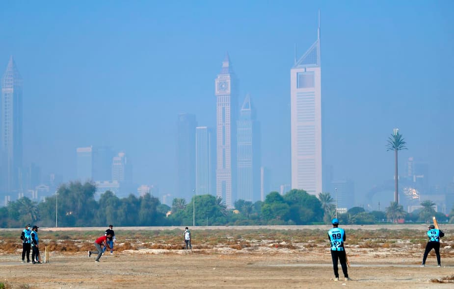 Des travailleurs jouent au criquet lors de leur journée de congé à Dubaï.
