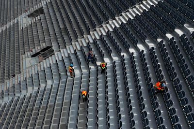 Des travailleurs assemblaient les sièges dans les estrades temporaires, mardi.