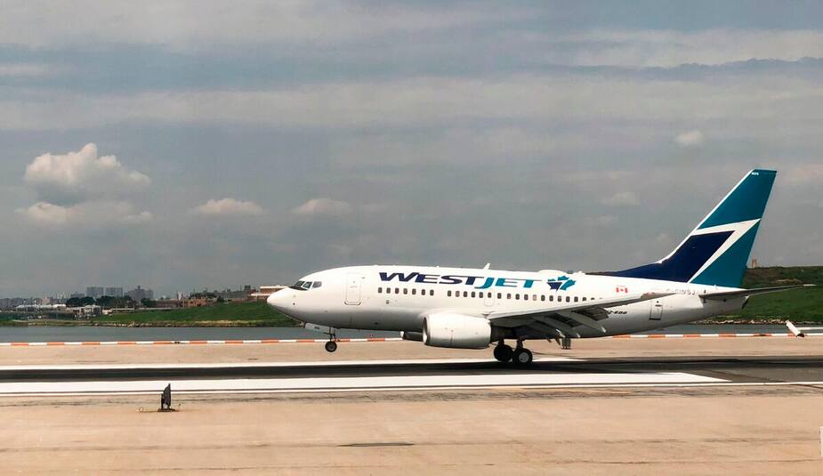 (FILES) In this file photo taken on July 28, 2018 a Westjet plane lands at La Guardia International Airport in New York. - A passenger jet taking winter-weary Canadians to Jamaica for a sunny holiday was forced to turn back after a passenger falsely claimed to have the coronavirus, the airline said February 4, 2020. The Westjet flight to Montego Bay was diverted to Toronto on Monday