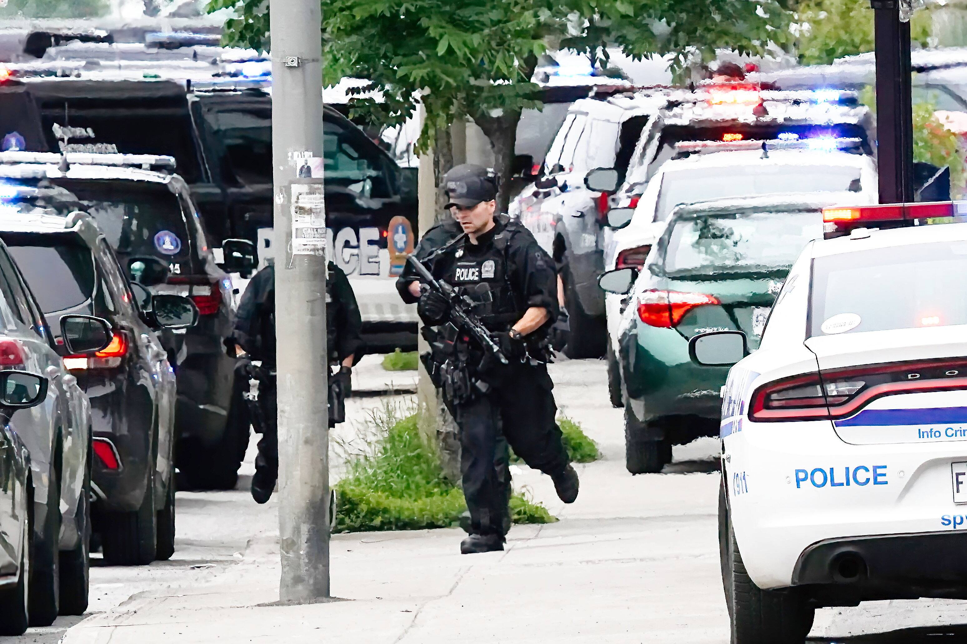 Des policiers à la recherche du suspect durant la vaste opération lundi.