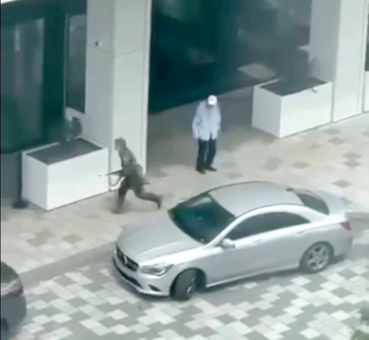 Sur ces images filmées par une citoyenne, on aperçoit le suspect armé et habillé en tenue militaire qui se rapproche d'un duo de policiers