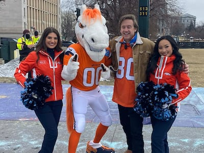 O maire Mike Johnston foi lançado no jogo da frenética comitiva dos Broncos em uma jornada laranja, na companhia de Miles, o mascote da equipe, assim como as líderes de torcida.