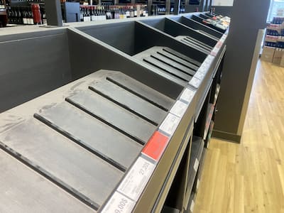 Estantes vacíos donde normalmente se colocaban los productos americanos en el SAQ Beaubien en marzo de 2025.