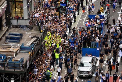NOVA IORQUE, NOVA IORQUE - 18 DE JUNHO: Os fãs aclamam os Knicks de Nova York durante a derrota e a reunião celebrando sua vitória no campeonato, no curso desquels passam um char transportant Karl-Anthony Towns e seus coéquipiers comemorando sua vitória na final de 2026 da NBA le 18 junho. Os Knicks de Nova York venceram os Spurs de San Antonio em cinco partidas para relatar seu primeiro título da NBA em 53 anos. (Foto: Angelina Katsanis / GETTY IMAGES AMÉRICA DO NORTE / Getty Images via AFP)