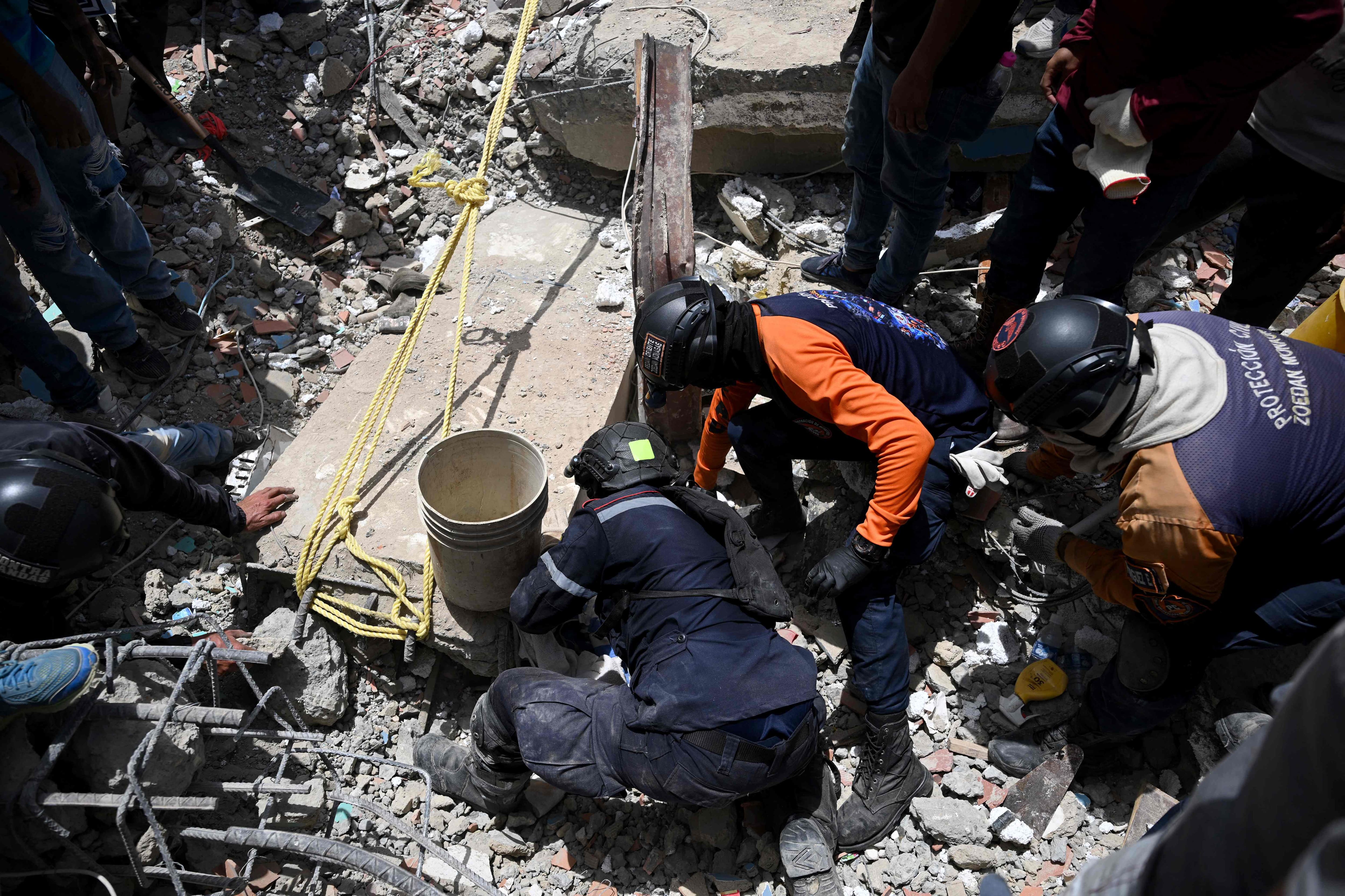 Des membres de la Protection civile vénézuélienne fouillent les décombres sur le site des bâtiments effondrés à Catia La Mar, dans l'État de La Guaira, au Venezuela, le 26 juin 2026, à la suite de séismes.