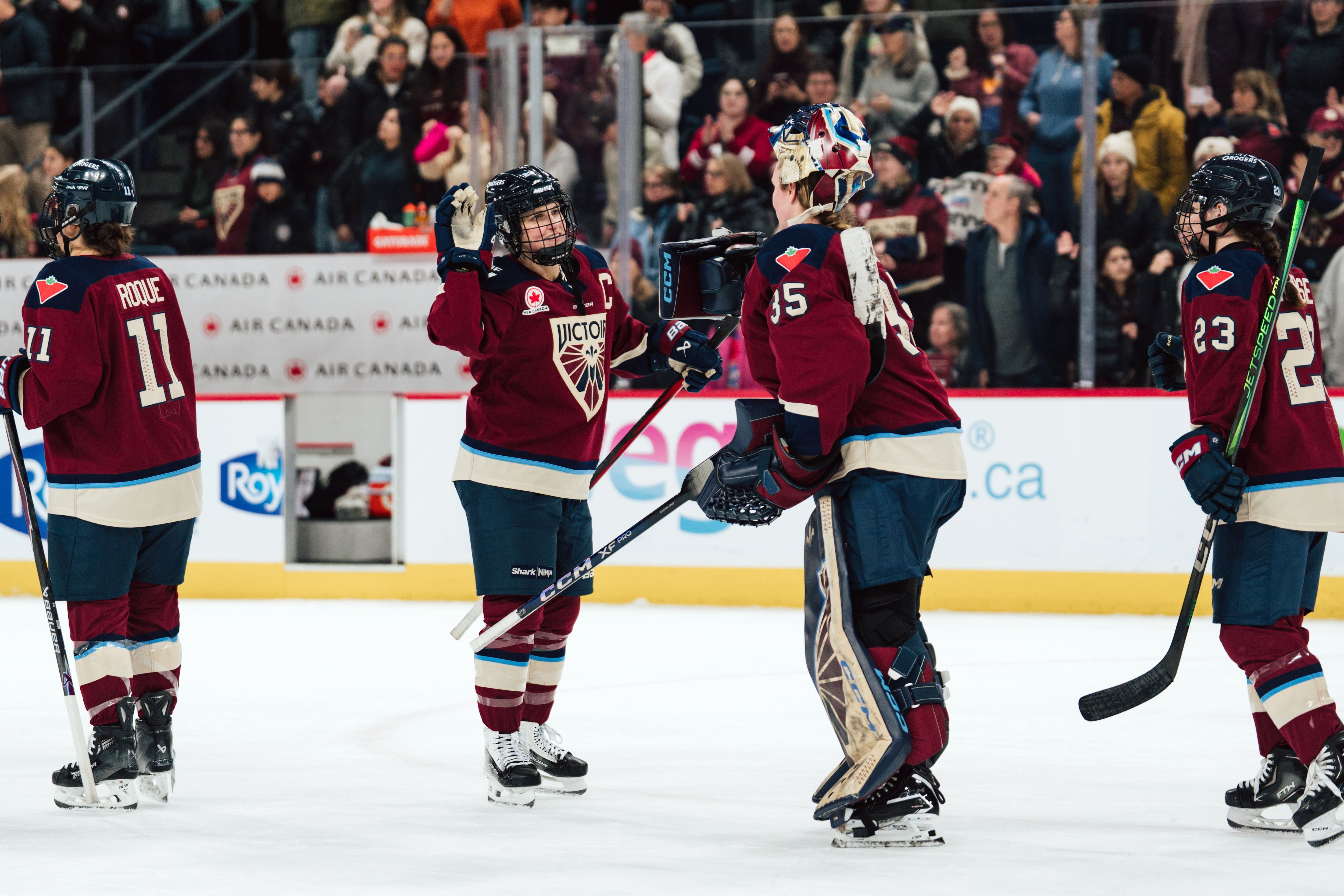 Marie-Philip Poulin félicite Ann-Renée Desbiens após um ganho de la Victoire, não loin d'Abby Roque et d'Erin Ambrose.