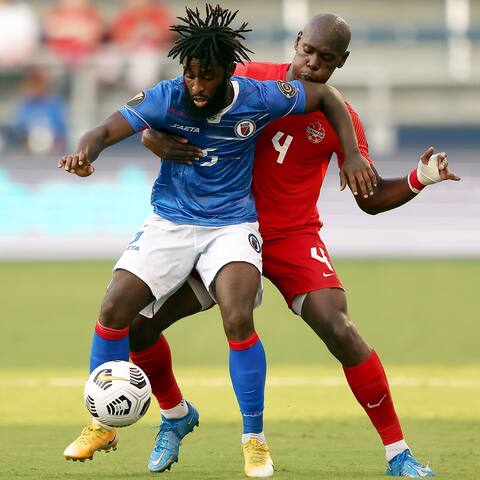 A battle for the ball between Stéphane Lampezi of Haiti and Kemal Miller of Canada.