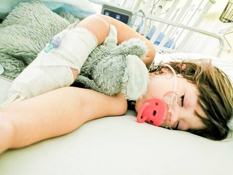 Hôpitaux débordés Amy sur son lit d’hôpital avec le soluté branché dans la main qui a engendré ses doigts tout noirs en raison d’un problème.