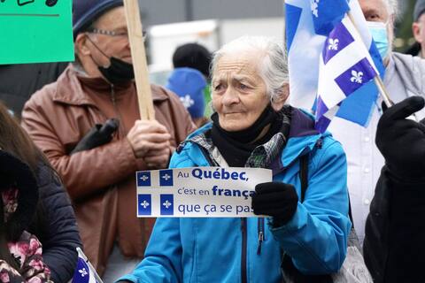 An opponent holds a sign during a demonstration.
