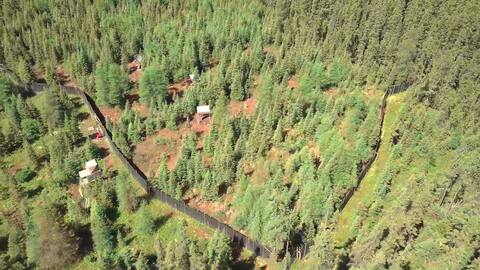 Sur cette image on aperçoit (de gauche à droite) la tour d'observation, la porte de l'enclos (en rouge) ainsi qu'une des mangeoires.