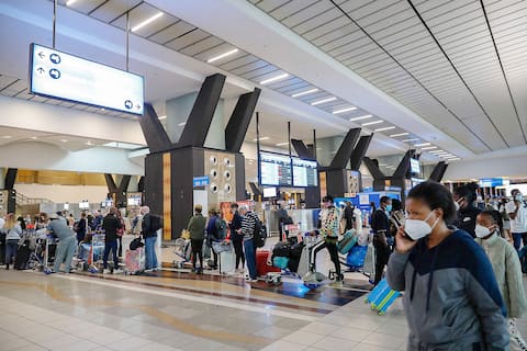 Yolcular, dün Güney Afrika'dan izole edilen gezegenin bir parçası olarak Güney Afrika'daki Johannesburg Havalimanı'nda sıraya girdi.