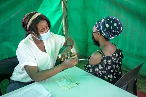 Bir sağlık çalışanı, Güney Afrika'nın Soweto kentindeki bir klinikte bir kadına aşı yapıyor.