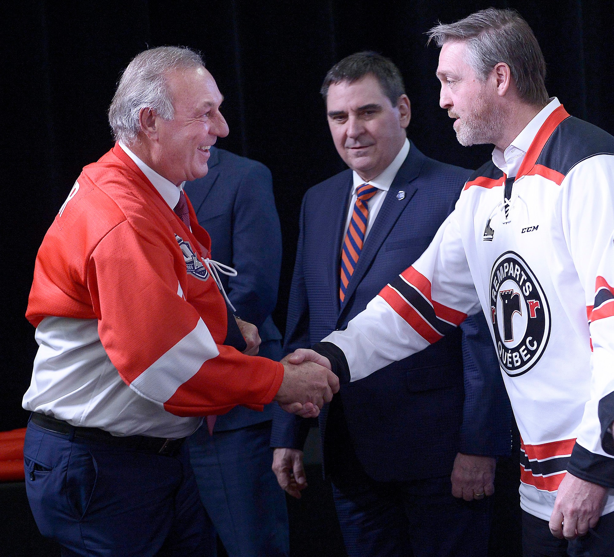 Guy Lafleur, enfilant un chandail des Remparts, et Patrick Roy s’étaient serré la main, sous les yeux du commissaire de la LHJMQ, Gilles Courteau, en février&nbsp;2019, à Québec.