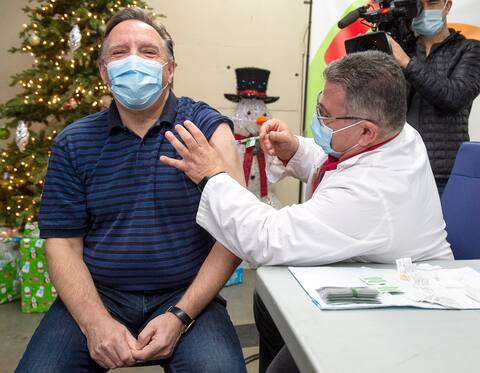 Franకోois Legalt smiles as he receives his third dose of the COVID-19 vaccine at the Olympic Stadium, a physician outside Canada.