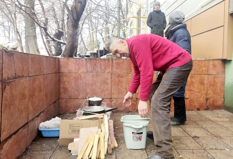 Glib Ivsieiev'in babası dışarıda küçük bir odun ateşinde su kaynatıyor.