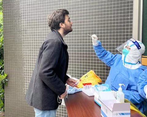 Çinli doktorlar ve hemşireler tarafından günlük tarama testleri yapılıyor.