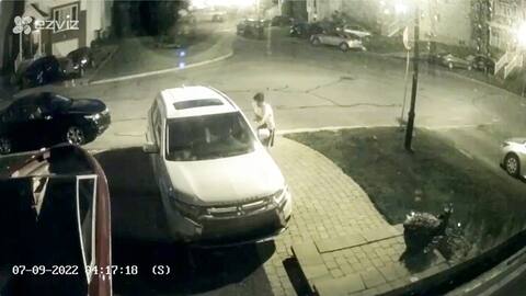 Un delincuente está tratando de abrir la puerta de este automóvil para robar las cosas que hay dentro.