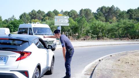A police officer prevents citizens from entering several areas affected by fires that are destroying thousands of hectares of forest in the Gironde.