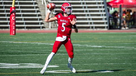 Le quart-arrière des Redbirds de McGill Eloa Latendresse-Regimbald tentant de lancer le ballon, ce samedi contre le Rouge et Or.