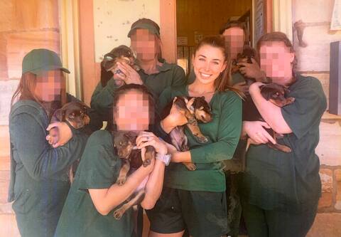 Mélina Roberge tient un chiot aux côtés d'autres détenues dans son uniform vert forêt, à Berrima, un peu plus d'un avant la fin de sa sentence. Une employée chargée de la bibliothèque avait eu la permission d'apporter une portée de chiots à la prison.