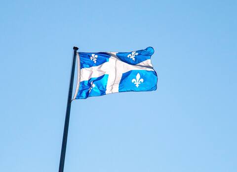 Drapeau du Québec contre le ciel bleu.
