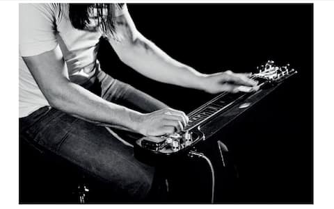 April 1975, David Gilmour playing steel guitar, at the Los Angeles Memorial Sports Arena, USA.
