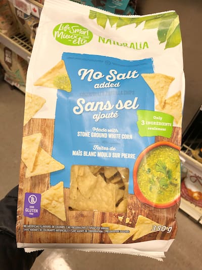 People eating tasty corn chips at white table