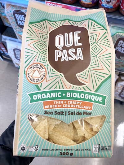 People eating tasty corn chips at white table