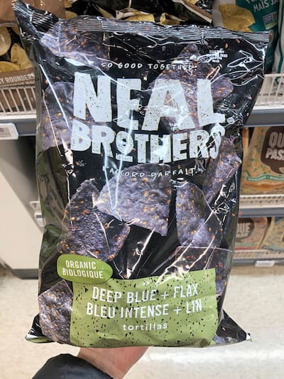 People eating tasty corn chips at white table