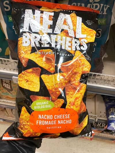 People eating tasty corn chips at white table