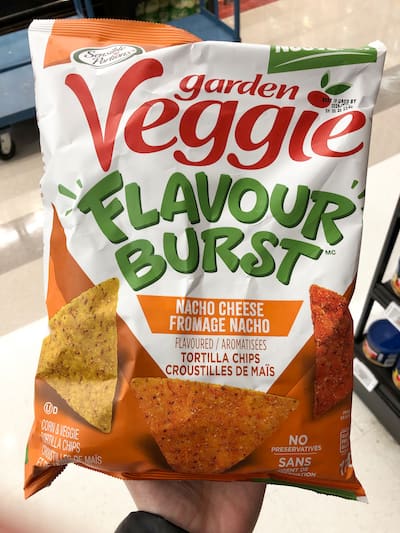 People eating tasty corn chips at white table