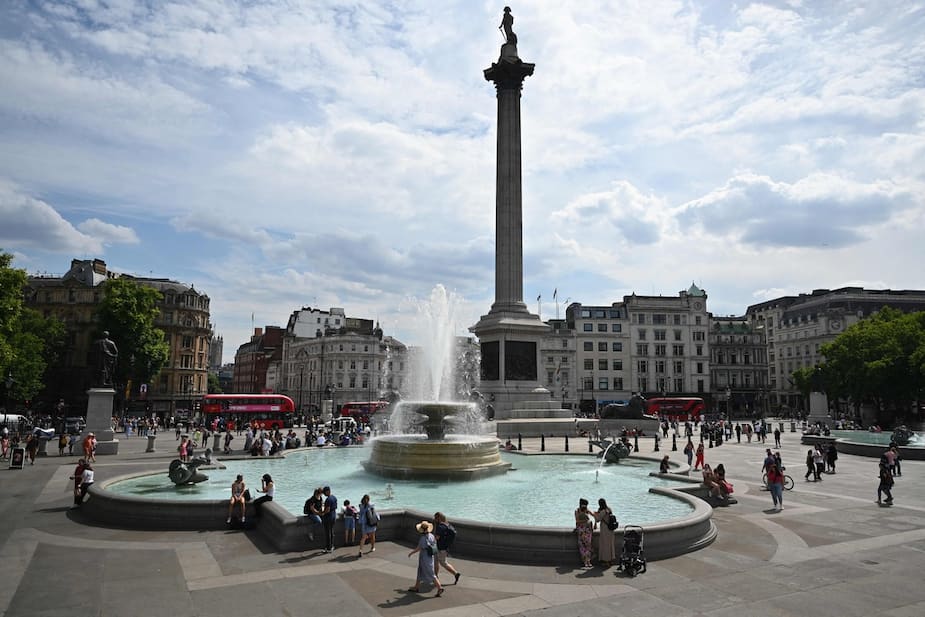 Des Britanniques se rafraîchissent en trempant leurs pieds dans l'eau de la fontaine de la place Trafalgar, à Londres.