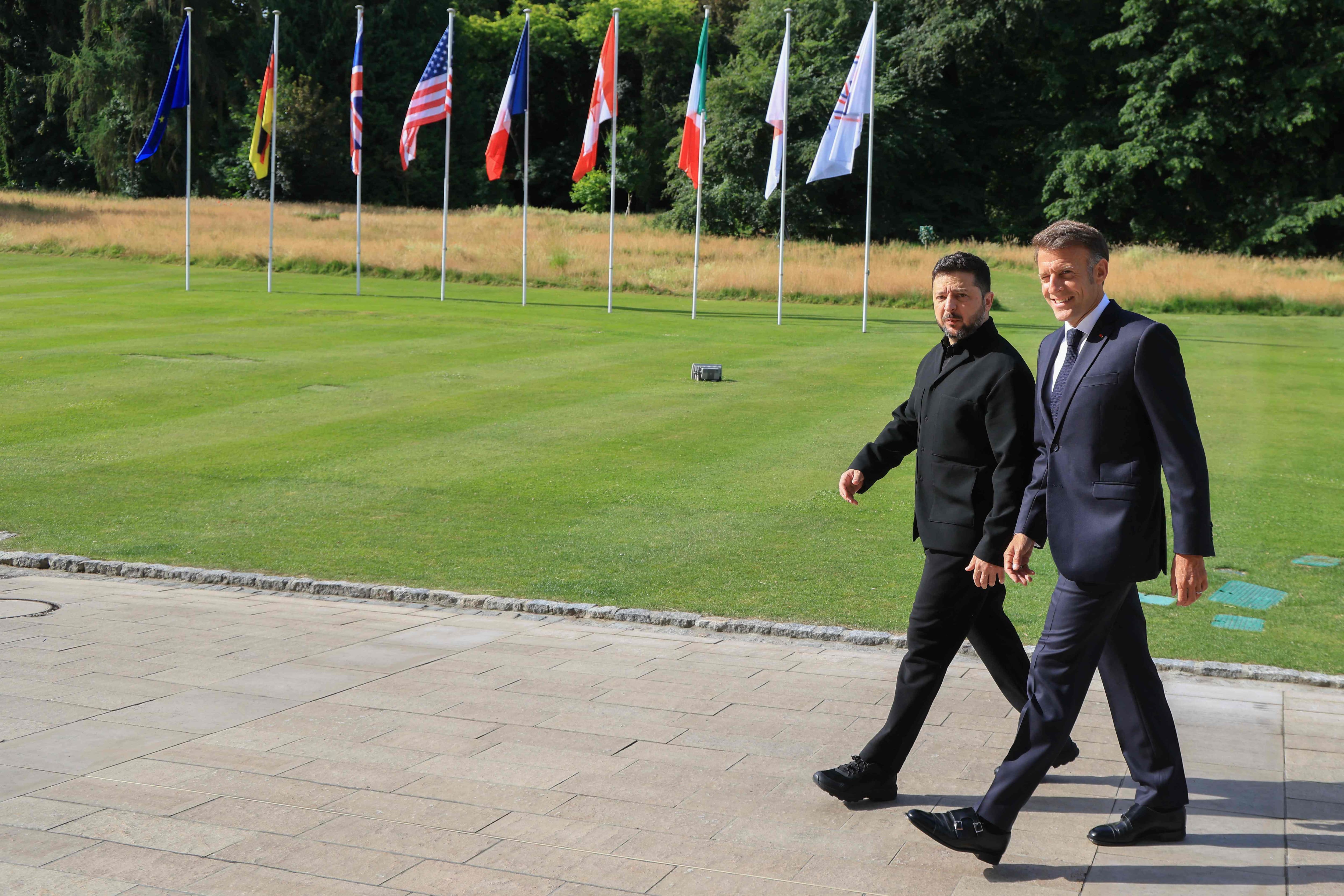 Le président français Emmanuel Macron salue le président ukrainien Volodymyr Zelensky avant la séance de travail réunissant les dirigeants du G7 et l'Ukraine, dans le cadre du sommet du G7, à Évian, dans l'est de la France, le 16 juin 2026.