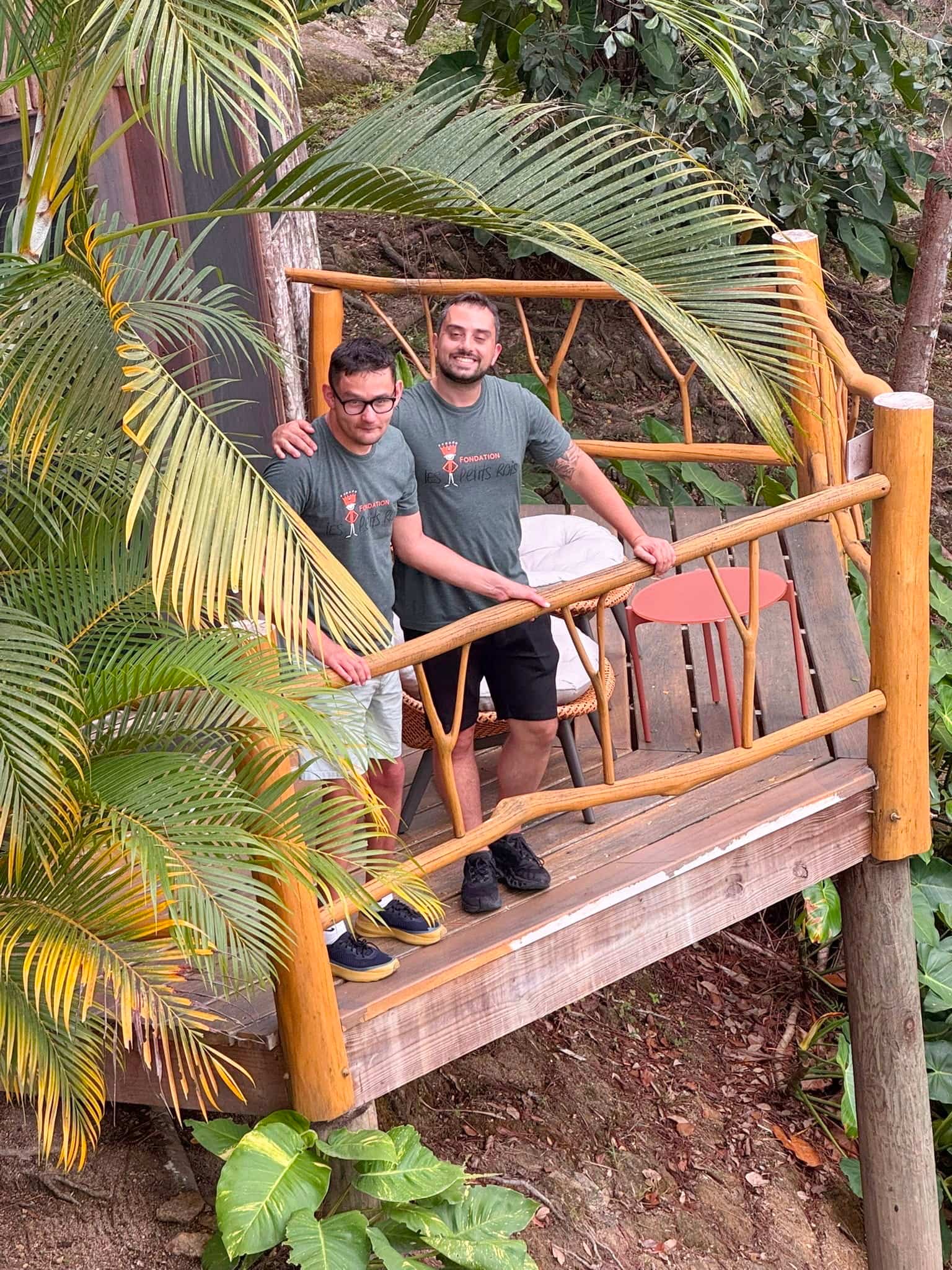 Henri-Louis Aguiar-Carrier et l’éducateur Josef Vincenzo Roppa posent sur un balcon de l’hôtel qui donne l’impression d’être juché dans les arbres.