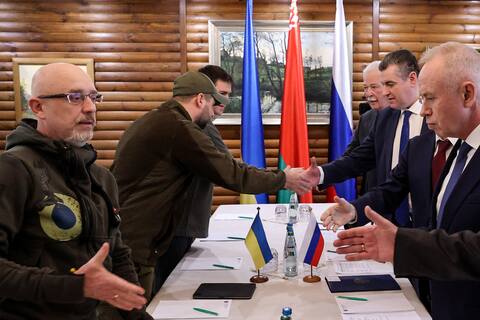 Ukrainian Defense Minister Oleksii Reznikov (left) shakes hands with Russian negotiators.
