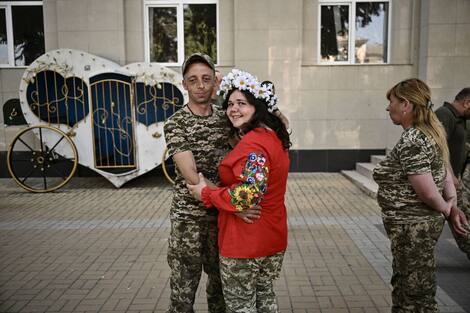 Los soldados ucranianos Khristina Lyota, de 23 años, y Volodymyr Mikhalchuk, de 28, se casaron en Druzkivka, región de Donbass, el 12 de junio de 2022 (Foto de ARIS MESSINIS / AFP)