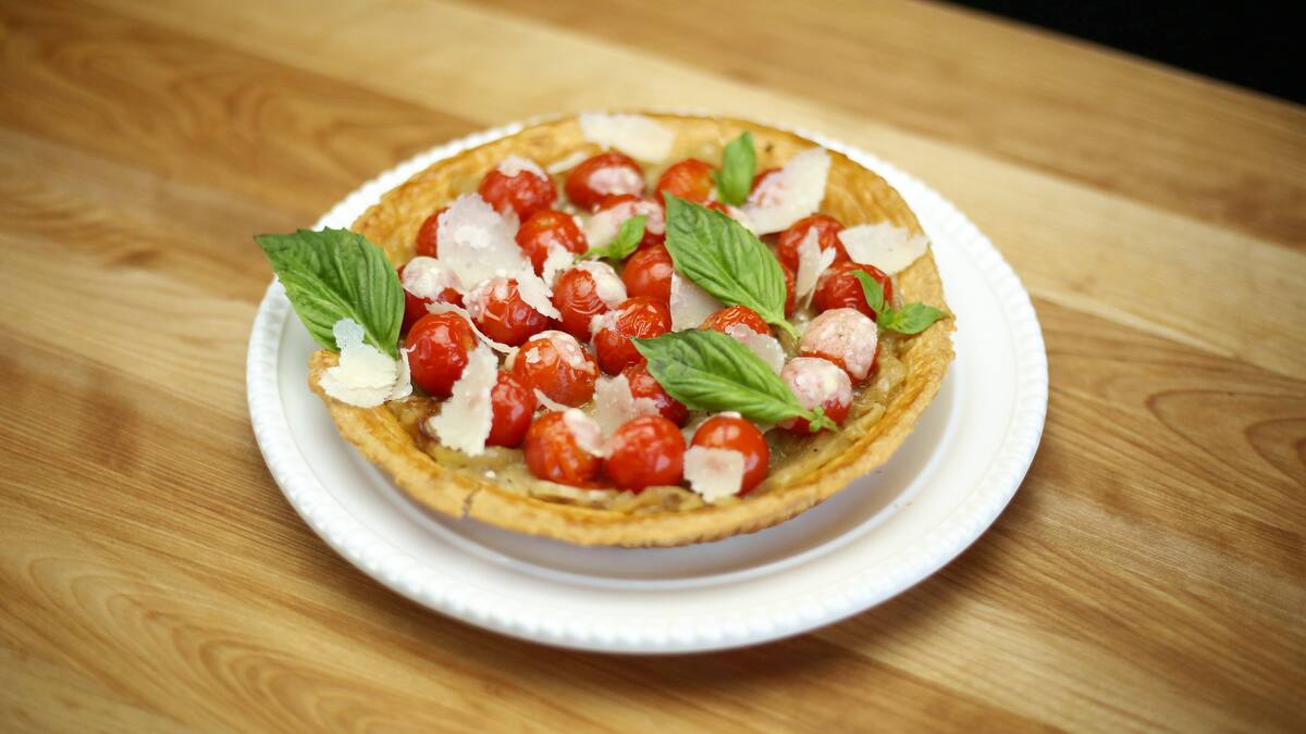Tarte aux tomates éclatées, oignons et copeaux de parmesan