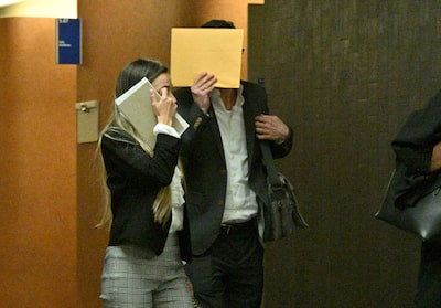 El Dr. Stephan Probst, exjefe de departamento del Hospital General Judío de Montreal, y su coacusada Wendy Devera (izquierda), acompañados por un abogado en su juicio por agresión sexual grupal, este jueves 13 de junio en el palacio de justicia de Montreal.