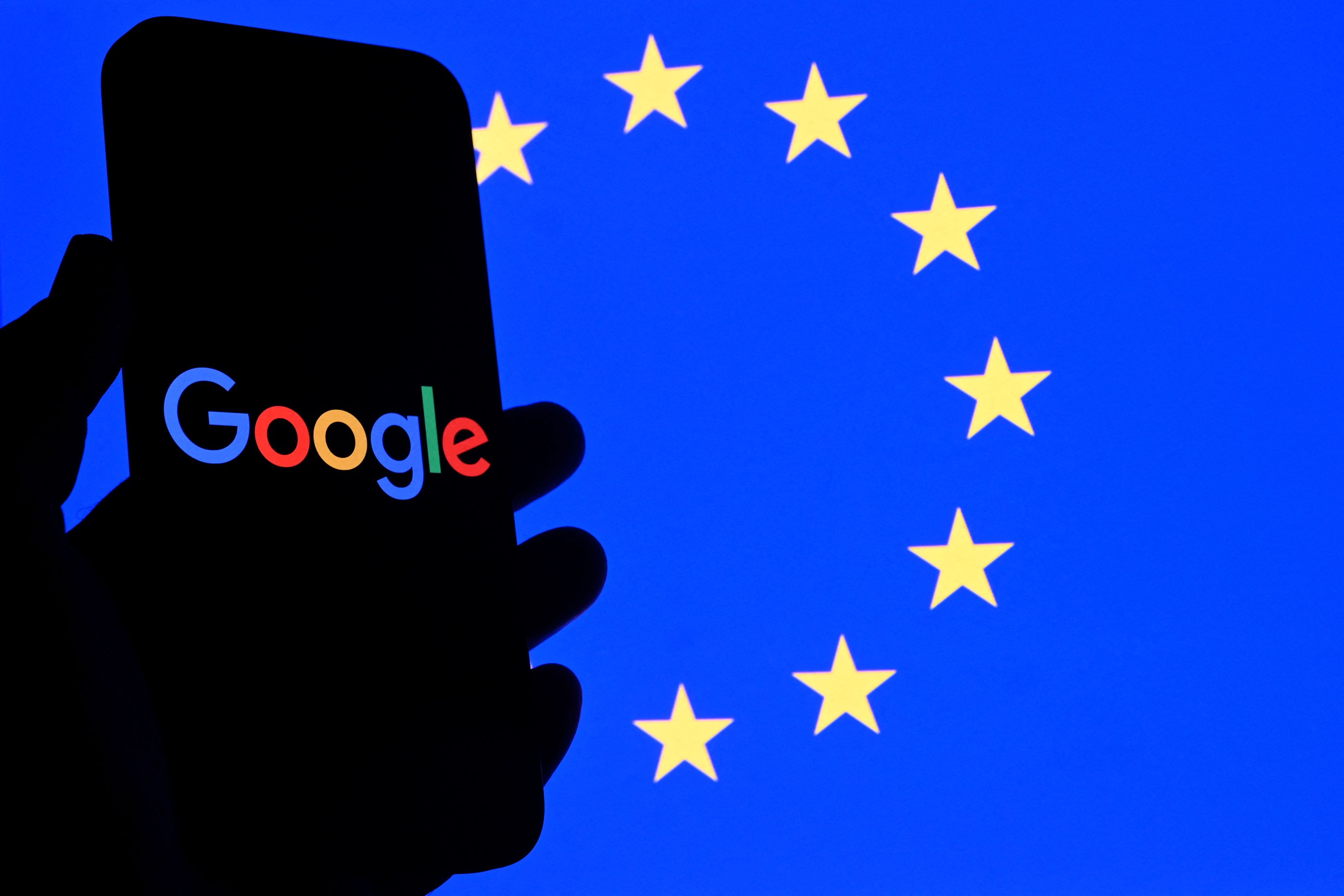 This illustrative photograph shows the Google logo displayed on a smartphone in front of a European Union flag in Brussels, September 29, 2025.
