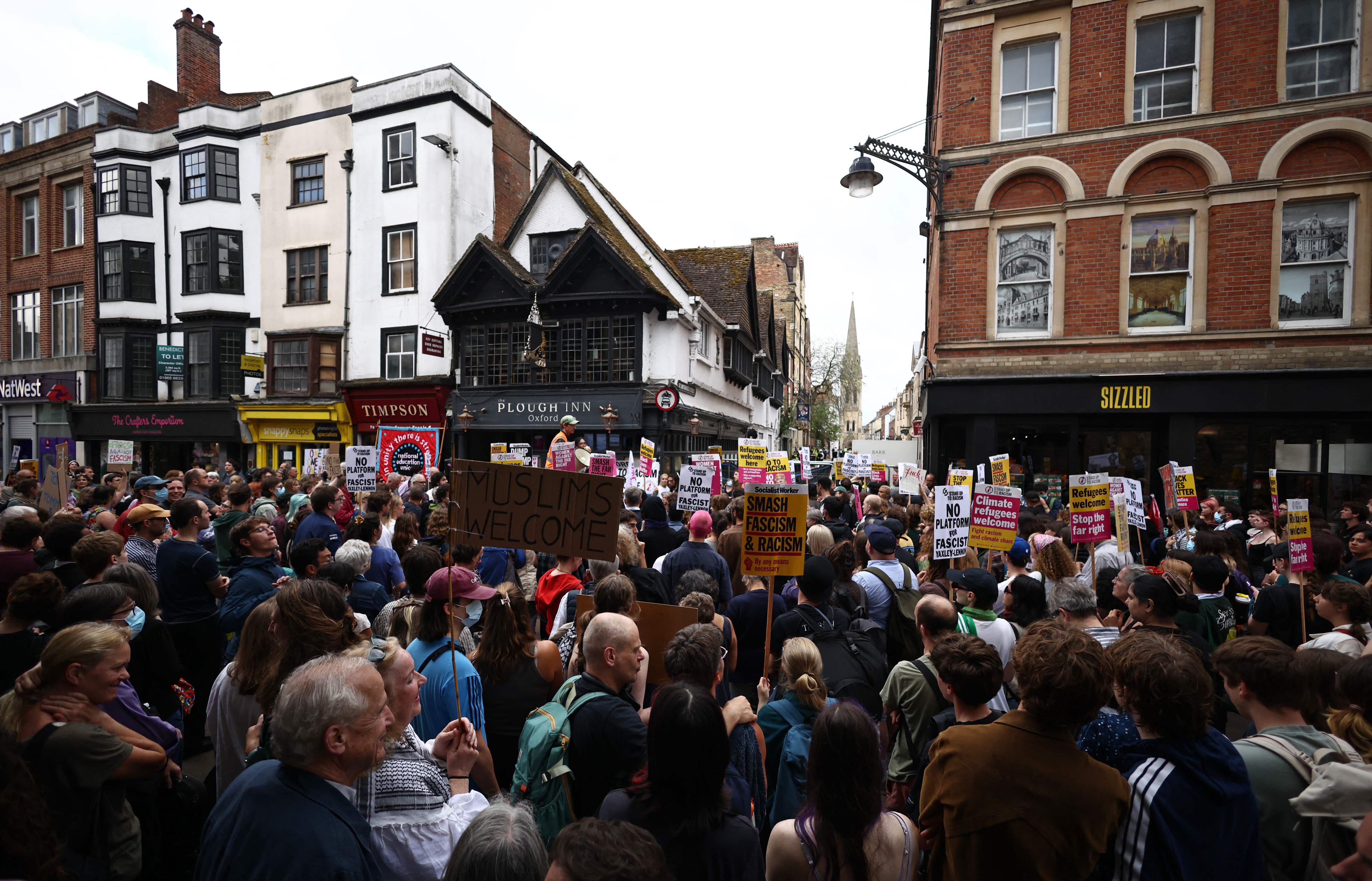 Des personnes participent à une contre-manifestation à proximité d'un rassemblement protestant contre un discours de l'activiste d'extrême droite britannique Tommy Robinson, à Oxford, dans l'ouest de l'Angleterre, le 17 juin 2026.