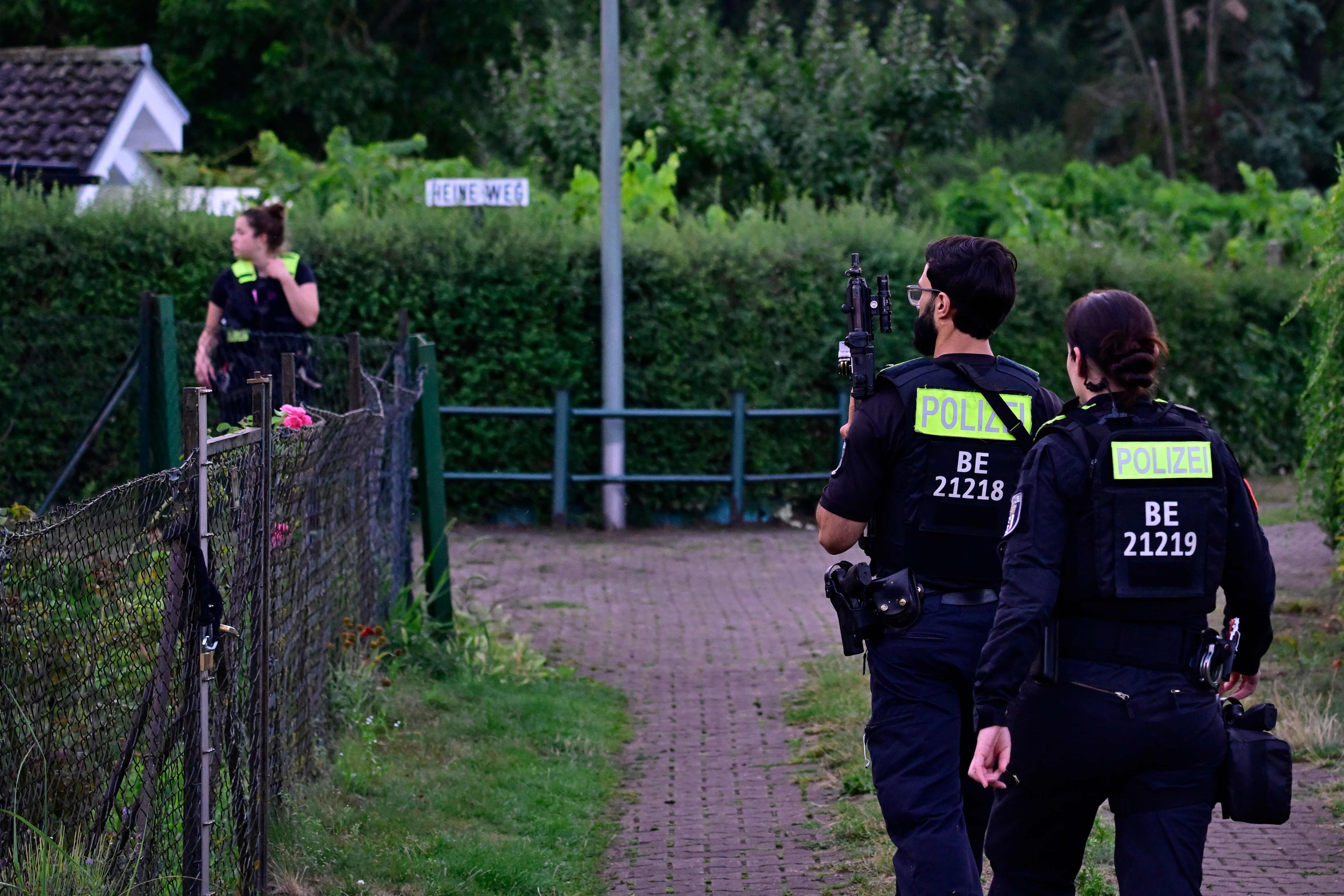 Police officers equipped with automatic weapons are seen on July 26, 2026 in a group of allotments in the Spandau district in western Berlin, near where the main suspect in the deadly attack that occurred the day before near the pride march was shot dead.