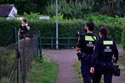 Police officers equipped with automatic weapons are seen on July 26, 2026 in a group of allotments in the Spandau district in western Berlin, near where the main suspect in the deadly attack that occurred the day before near the pride march was shot dead.